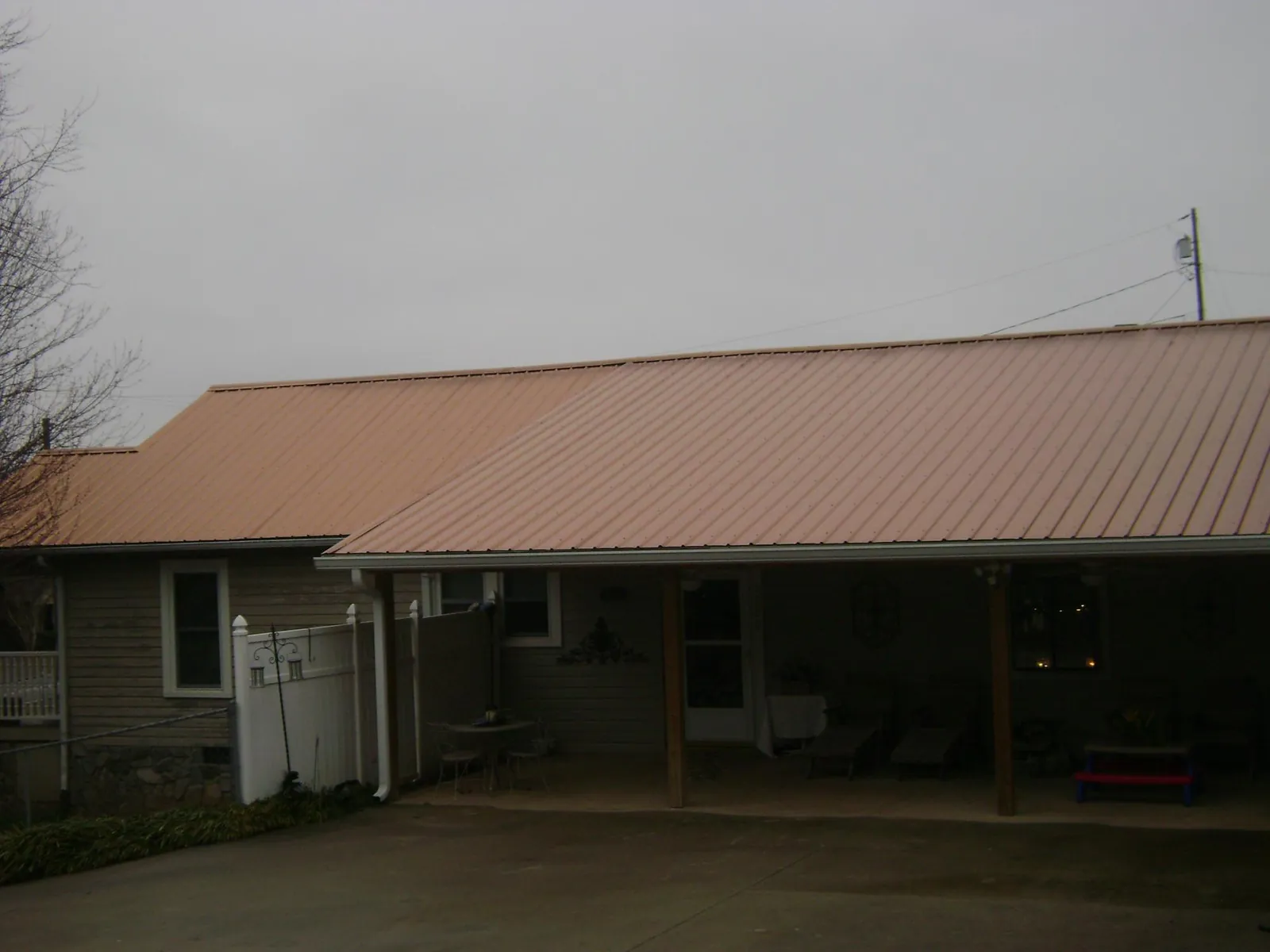 Copper toned metal roof over a wide covered patio in Arlington